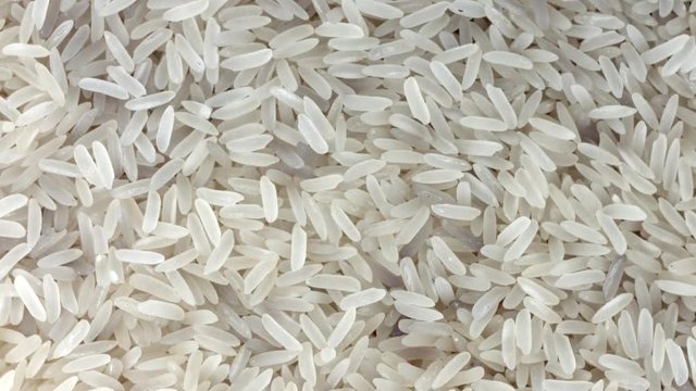 Rice background, closeup raw rice rotation