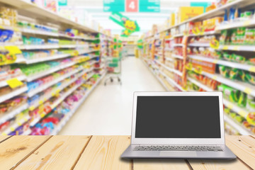 Laptop with blank screen on wooden table with Shelf in a department