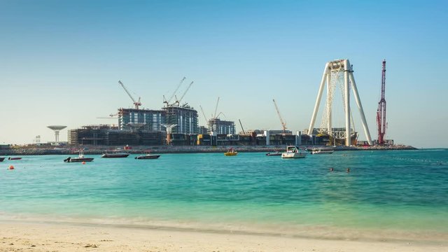 sunny day dubai marina beach wheel construction hotel panorama 4k time lapse uae
