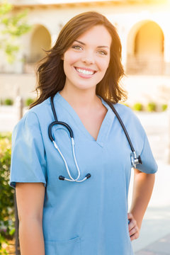 Portrait of Young Adult Female Doctor or Nurse Wearing Scrubs and Stethoscope Outside.