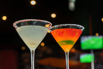 I count on some cocktails in a bar on a marble table on a black restaurant background.