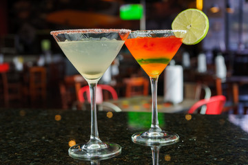 I count on some cocktails in a bar on a marble table on a black restaurant background.