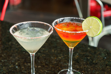 I count on some cocktails in a bar on a marble table on a black restaurant background.