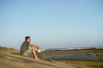 Man on Rocks with Book and Music
