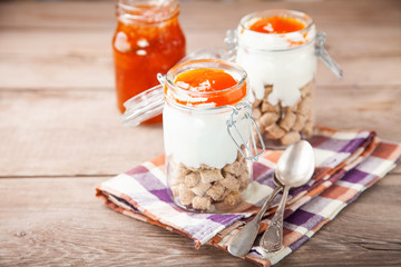 Breakfast in a jar - oat bran, yogurt and jam. Selective focus. Copy space
