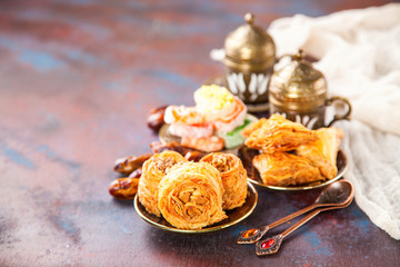 Traditional arabic desserts Kunafa and Baklava with honey and nuts. Selective focus. Copy space.