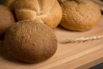 Fototapeta na wymiar Tasty fresh buns on the wooden background