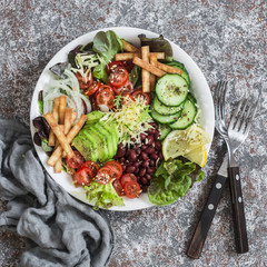 Vegetables, beans, avocado and cheese salad on a light background, top view. Delicious appetizer or snack