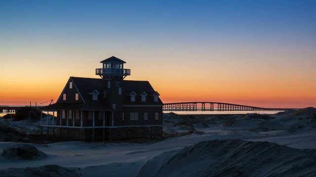 Lifeboat Station with Outer Banks NC Sunset with Traffic Flowing over the Herbert C. Bonner Bridge into the Evening with a Vibrant Color Sky