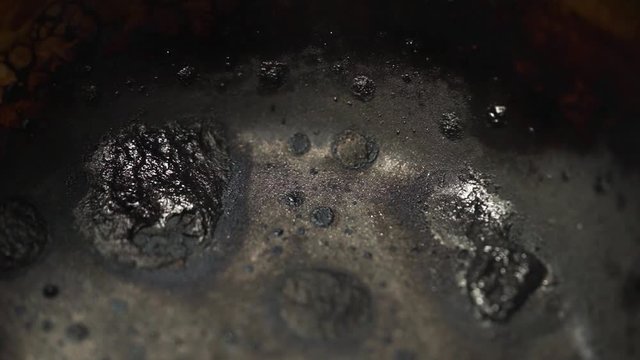 Black old metal background. The surface of the pan to the oven. Smokes burnt charred pot close up.