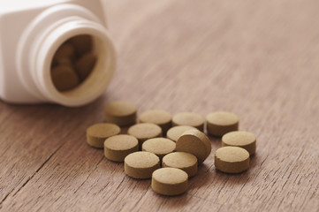 Fototapeta na wymiar herb medicine in pill on wood background