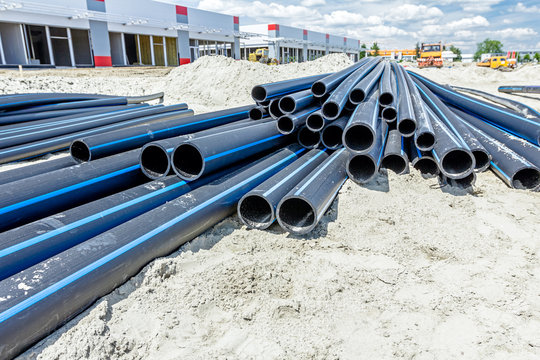 Distributed plastic pipes are stacked, piled temporarily at building site