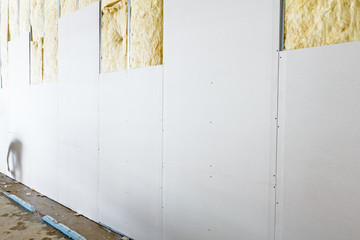 Front view of gypsum wall, plasterboard is under construction - obrazy, fototapety, plakaty