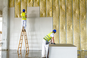Riggers are working on thermal partition dry wall with mineral wool