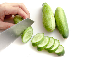 Cutting cucumbers into small slices on white background isolated