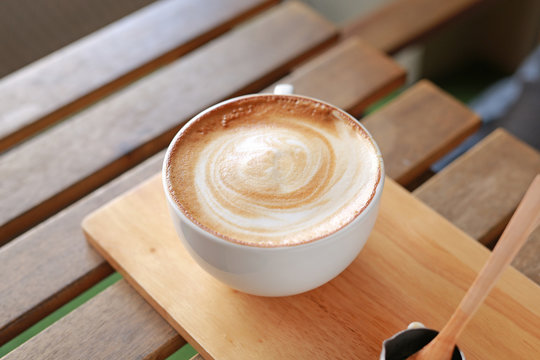 Hot latte coffee on wooden table.