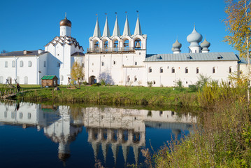 Fototapeta na wymiar October day in the monastery pond. View of the bell tower of the Tikhvin Assumption monastery, Russia
