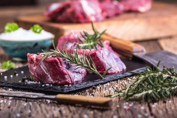 Raw beef meat. Raw beef tenderloin steak on a cutting board with rosemary pepper salt in other positions.