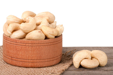 cashew nuts in a wooden bowl on the board isolated  white background