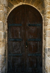 Fototapeta na wymiar A brown old wooden door on grunge brick wall in the centre of Baku Azerbaijan