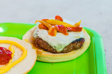 Homemade burgers for a picnic on a green plate.