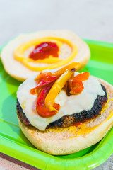 Homemade burgers for a picnic on a green plate.