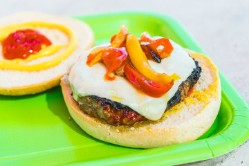 Homemade burgers for a picnic on a green plate.