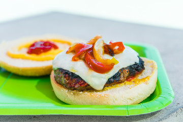 Homemade burgers for a picnic on a green plate.
