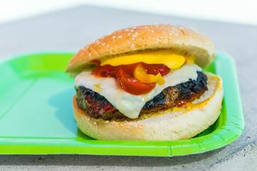 Homemade burgers for a picnic on a green plate.