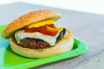 Homemade burgers for a picnic on a green plate.