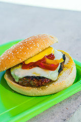 Homemade burgers for a picnic on a green plate.