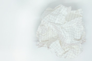 close up of a  crumpled grid paper on white background