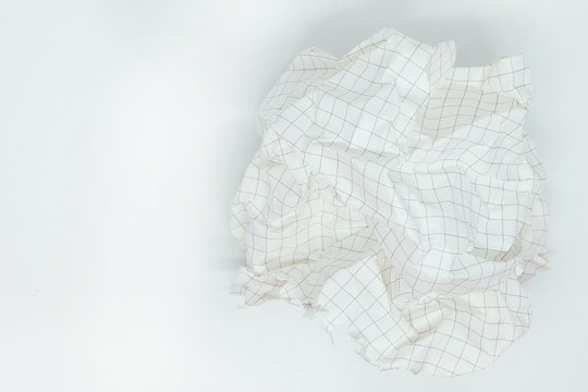 close up of a  crumpled grid paper on white background