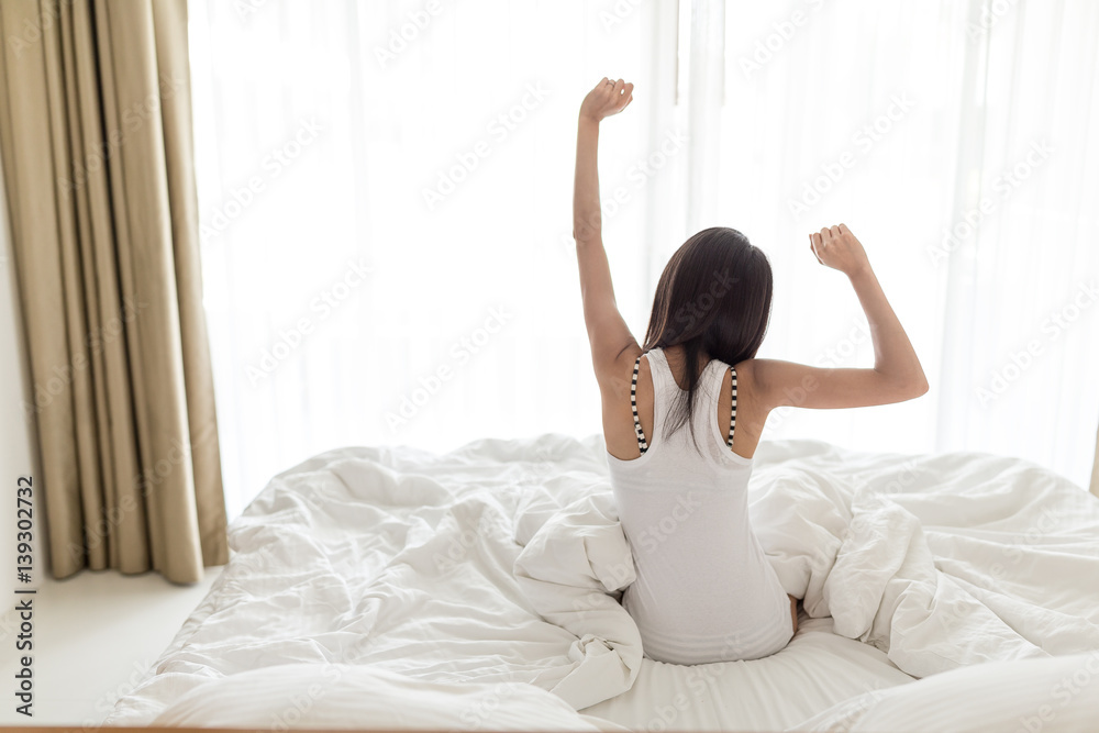 Poster Woman stretching in bed after wake up