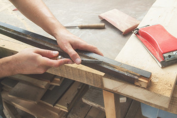 Carpenter working on the raw board / wood.