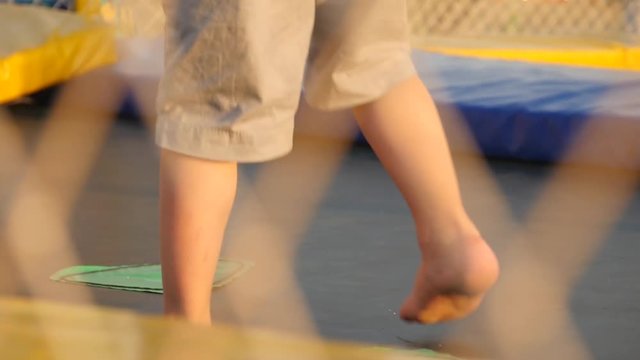 legs of children running and jumping on the trampoline