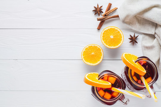 Two Fruit Tea In Vintage Glass Jars With Drinking Straw On White Wooden  Background Top View. Vintage Mason Jars With Ice Red Tea, Orange, Cinnamon And Star Anise On White Table, Flat Lay.
