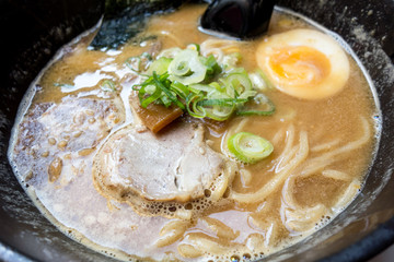 Tasty Japanese ramen soup bowl with pork, egg, and vegetables