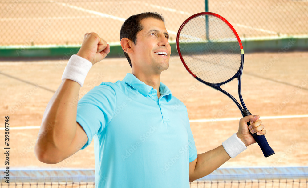 Canvas Prints Portrait of a young male tennis player celebrating a victory on a clay court