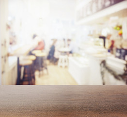 wooden table top with blur of coffee shop interior as background