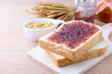 Bread with jam grape on wood background