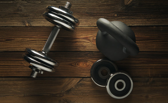 Top view of black iron kettlebell, dumbbell on wooden floor Sport background with copyspace  Weight lifting exercise concept.