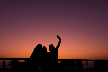 Silhouette of friend enjoying for selfie