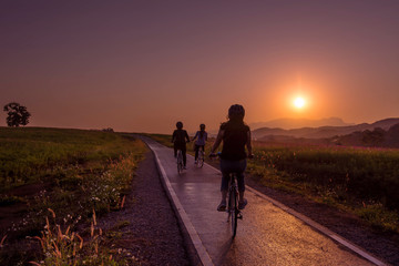 Silhouette of friend on bicycle during sunrise