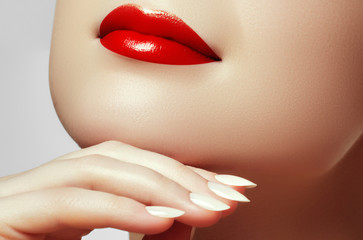 Сloseup shot of perfect lips. Sexy woman's mouth. Smiling young girl. Natural plump full lips with bright red lip makeup. Lips augmentation. Manicure and makeup