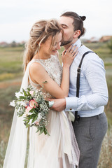 Wedding. Wedding by the sea. Young couple in love, bearded groom and bride in wedding dress at the...