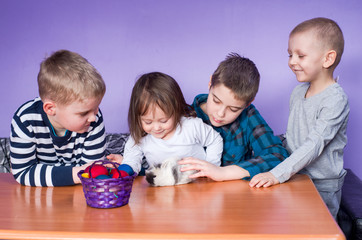 Happy children playing on Easter with a bunny