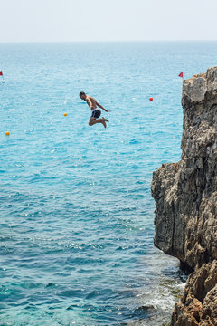 man cliff jumping into the sea in Cyprus