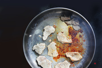 The meat is fried in a pan. chicken. Meat. The meat is frying. Electronic plate. Cooking. Kitchen. Tasty food. Close-up