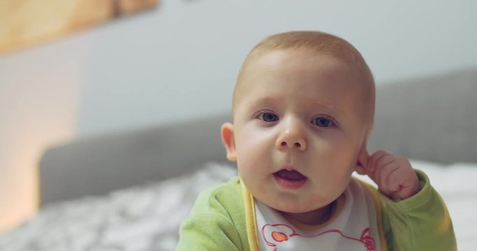 A cute little boy is looking into the camera and smiling